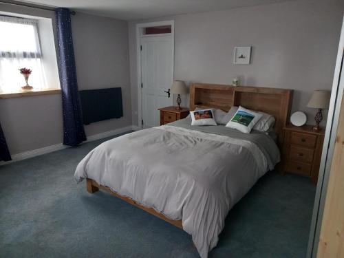 a bedroom with a large bed and a window at 3 bed corner terrace house by the sea Wicklow town in Wicklow
