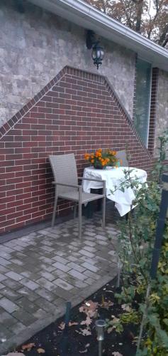 a table and a chair on a brick wall at Brīvdienu mājas in Jūrmala