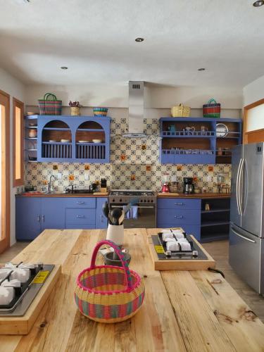 a kitchen with blue cabinets and a wooden table at Casa Carmen in San Cristóbal de Las Casas