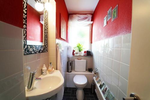 a bathroom with a white toilet and a sink at Ferienwohnung im Haus Lotus mit großem Balkon und Garten in Bad Urach