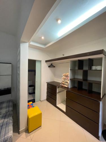 a room with a bed and a yellow stool at BERTIOGA suítes na praia centro in Bertioga