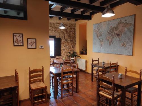 um restaurante com mesas e cadeiras e um mapa na parede em Casa Rural El Botánico em Durón