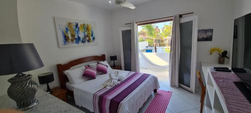 a bedroom with a bed and a view of a pool at Pousada Caminho da Praia in Jericoacoara