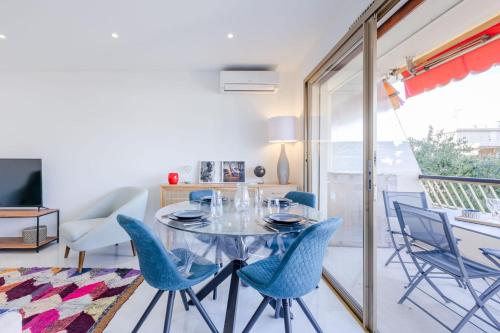 une salle à manger avec une table en verre et des chaises bleues dans l'établissement 1-Br Apartment 5 min on foot from the Croisette, à Cannes