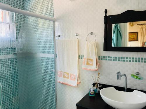 a bathroom with a sink and a shower with a mirror at Pousada Sítio da Luzia in Engenheiro Passos