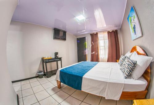 a bedroom with a bed and a television in it at Hotel La Vid La Fortuna in Fortuna