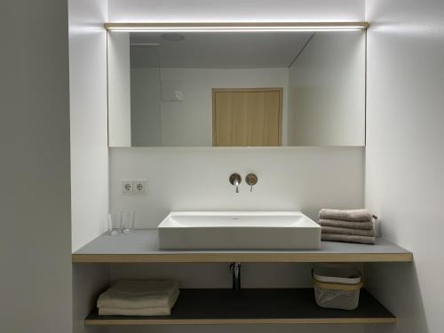 a bathroom with a white sink and a mirror at Bregenzerwaldblick in Schwarzenberg im Bregenzerwald