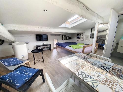 une chambre avec un lit, une table et des chaises dans l'établissement St Louis Studio mansardé atypique climatisé, à Sète