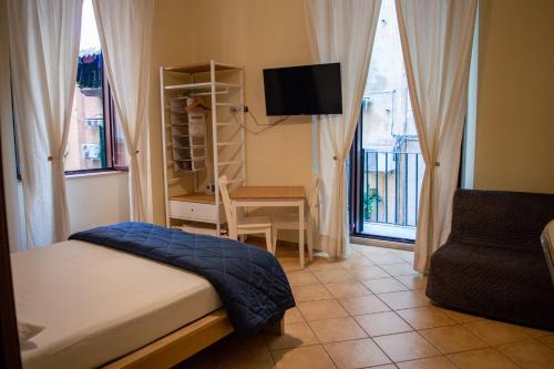 - une chambre avec un lit, un bureau et une télévision dans l'établissement B&B il Gobbetto, à Naples