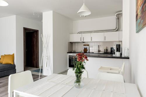 een witte keuken en een woonkamer met een witte tafel en stoelen bij Amphora Luxury Apartment with FREE private Parking and cozy Balcony in Boedapest