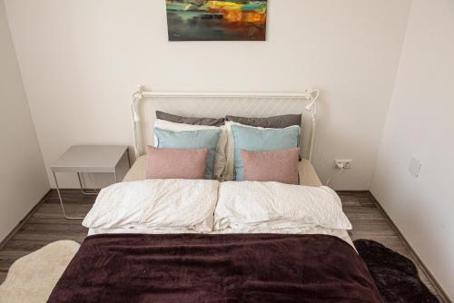 een bed met roze en blauwe kussens in een kamer bij Amphora Luxury Apartment with FREE private Parking and cozy Balcony in Boedapest