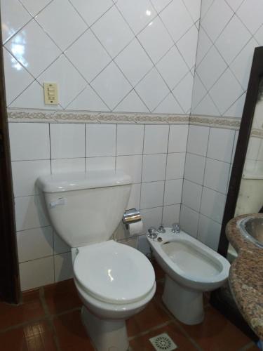 a bathroom with a white toilet and a sink at Jardín de Naipí 2 in Puerto Iguazú