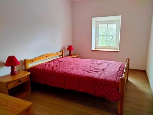 um quarto com uma cama vermelha e uma janela em Gîte Saint-Étienne-Lardeyrol, 3 pièces, 4 personnes - FR-1-582-332 em Saint-Étienne-Lardeyrol