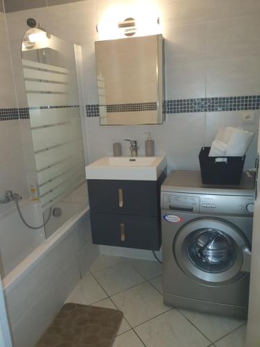 a bathroom with a washing machine and a sink at Apart 5 personnes, 1min Gare d'Annemasse, Genève 5km in Annemasse