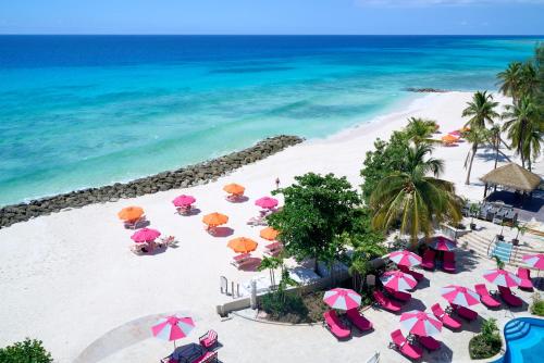 an aerial view of a beach with umbrellas and the ocean at O2 Beach Club & Spa All Inclusive by Ocean Hotels in Christ Church