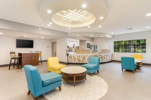 a waiting room with colorful chairs and a table at Red Lion Inn & Suites Nashville Airport in Nashville