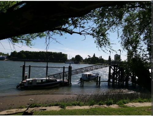 two boats are docked at a dock on a river at Lugar confortable y tranquilo in Patagones