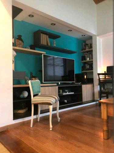 a living room with a chair and a flat screen tv at Lugar confortable y tranquilo in Patagones