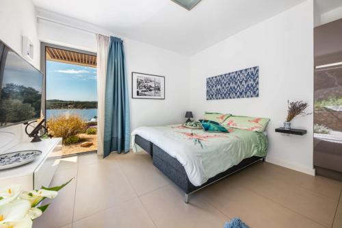 a bedroom with a bed and a desk and a window at Villa del Mar Deluxe in Mali Lošinj