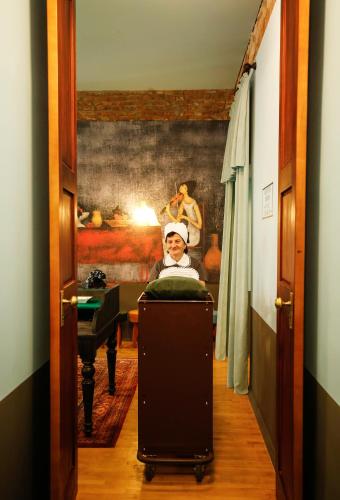 a child is sitting in a room with a suitcase at Hotel Memoire Kutaisi in Kutaisi