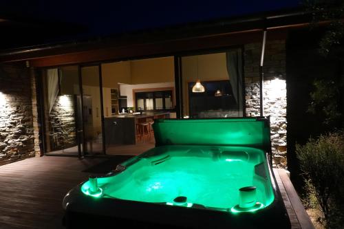 a green hot tub sitting on a deck at night at Takapō Retreat - Lake Tekapo in Lake Tekapo
