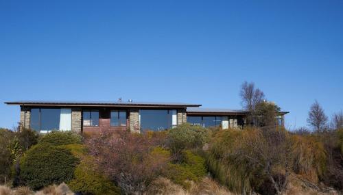 a house on top of a hill with trees at Takapō Retreat - Lake Tekapo in Lake Tekapo