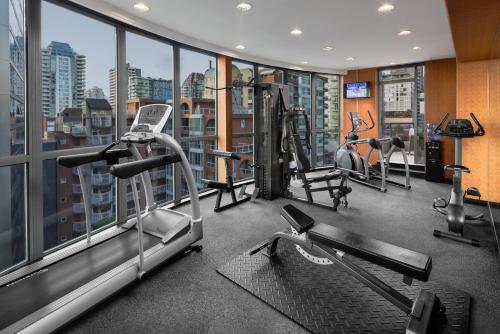 una palestra con tapis roulant e macchine in un edificio di The Parker Hotel Vancouver a Vancouver