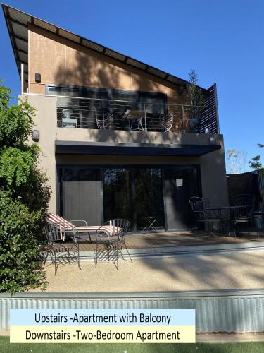 a building with a balcony with chairs and tables at Adelphi Apartments 3 or 3A - Downstairs 2 Bedroom or Upstairs King Studio with Balcony in Echuca
