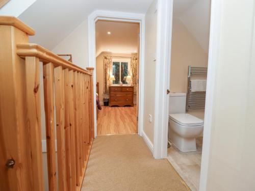 a bathroom with a toilet and a staircase in a house at The Cottage At Barrow Mead in Bath
