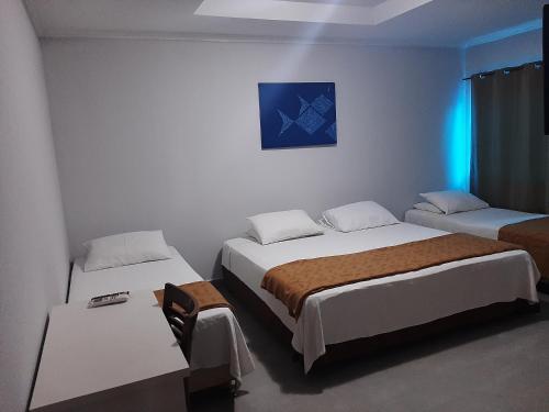 a room with two beds and a blue light at PEDRA BONITA PRECIOSO HOTEL ltda in Itaboraí