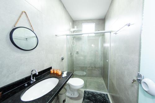 a bathroom with a shower and a sink and a toilet at Jahu Center Plaza Flats in Jaú