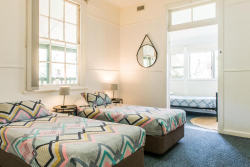 two beds in a room with two windows at The Retreat Port Stephens in Anna Bay