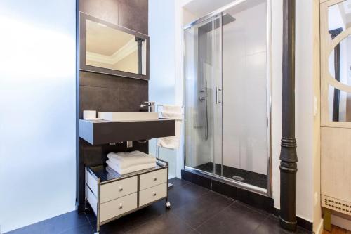 een badkamer met een wastafel en een glazen douche bij Charming La Casa de La Luna in Madrid