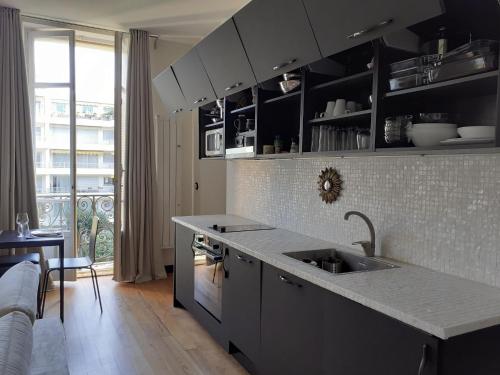 eine Küche mit einer Spüle und einer Arbeitsplatte in der Unterkunft Sublime appartement centre, parc et parking in Biarritz