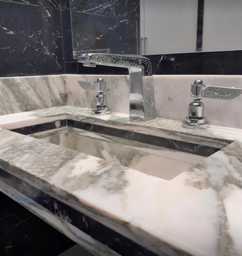 - un lavabo sale avec deux robinets dans la salle de bains dans l'établissement Sublime appartement centre, parc et parking, à Biarritz