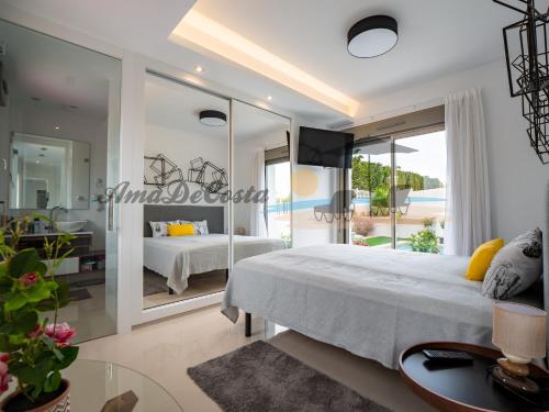 1 dormitorio con cama y espejo grande en Villa Dominica en Rojales