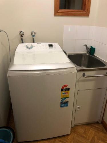 a kitchen with a sink and a small refrigerator at Serenity on Sturt in Ballarat