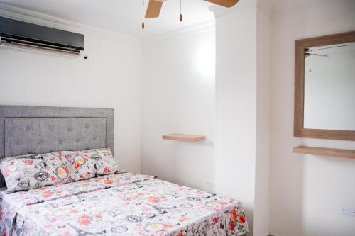 a bedroom with a bed with a floral bedspread at Rodadero Apartment in Rodadero