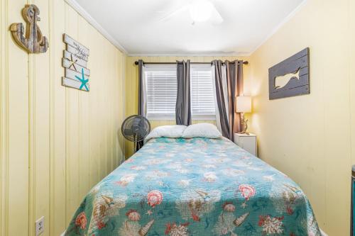 a bedroom with a bed with a colorful comforter at Seaward Villas 5 in Myrtle Beach