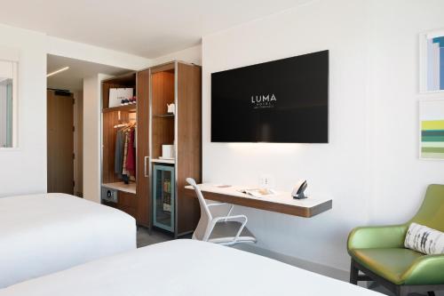 a hotel room with a desk and a tv on the wall at LUMA Hotel San Francisco in San Francisco