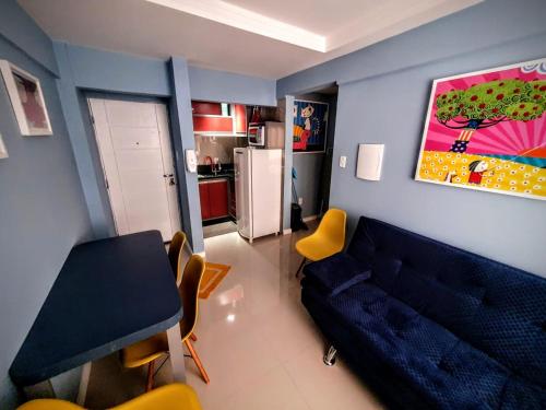sala de estar con sofá azul y mesa en APTO BEIRA MAR BALNEARIO CAMBORIU, en Balneário Camboriú