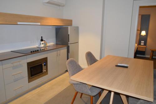 a kitchen with a table and chairs and a microwave at Quality Hotel Parklake Shepparton in Shepparton