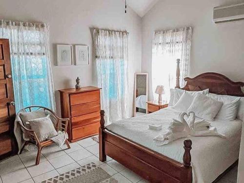 sypialnia z dużym łóżkiem i krzesłem w obiekcie Vacation Home Blue Lotus- Gold Standard Certified w Caye Caulker