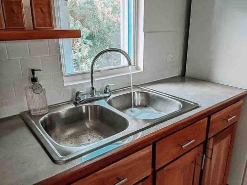 fregadero de acero inoxidable en una cocina con ventana en Vacation Home Blue Lotus- Gold Standard Certified, en Caye Caulker