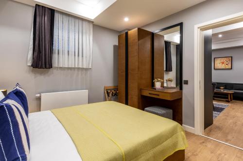a bedroom with a bed and a desk and a mirror at SALA SUITES in Istanbul