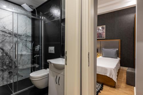 a bathroom with a toilet and a shower and a bed at SALA SUITES in Istanbul