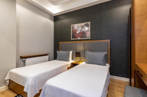 two beds in a room with black walls at SALA SUITES in Istanbul