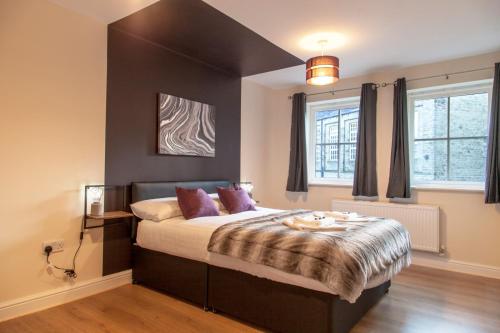 a bedroom with a large bed with purple pillows at Stunning Holiday Home Woodcote View in Oakworth