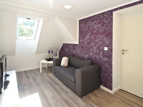 a living room with a couch and a purple wall at Holiday home in Elbingerode with garden in Rübeland