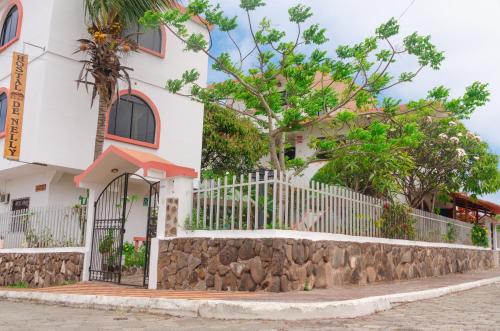 a white building with a fence and trees at Casa de Nelly in Puerto Baquerizo Moreno